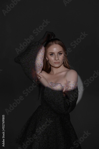 Fototapeta Elegant person posing gracefully in dark background with soft lighting and a stylish outfit