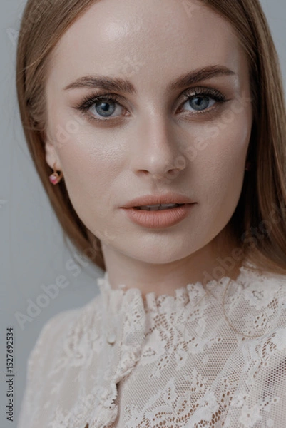 Fototapeta Captivating portrait of a woman with lace attire and subtle makeup highlighting her natural beauty in a neutral setting