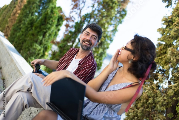 Fototapeta Cheerful friends sharing a joyful moment outdoors, laughing and enjoying each other's company on a sunny day