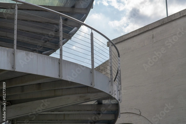 Fototapeta helical pedestrian ramp project in external steel, modern and innovative design staircase, for contemporary architecture. stainless steel design is designed for a pedestrian overpass in a public area.