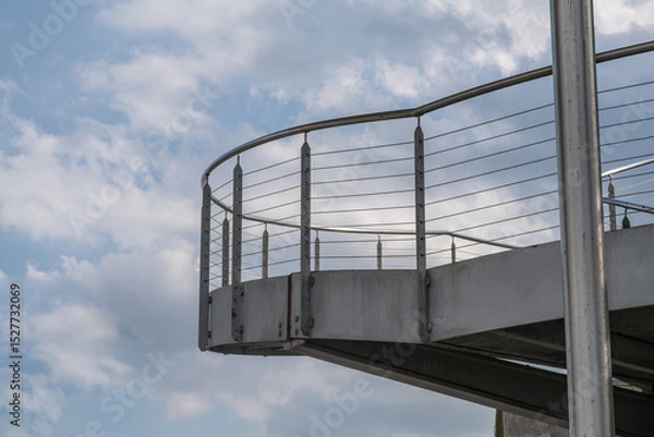Fototapeta helical pedestrian ramp project in external steel, modern and innovative design staircase, for contemporary architecture. stainless steel design is designed for a pedestrian overpass in a public area.