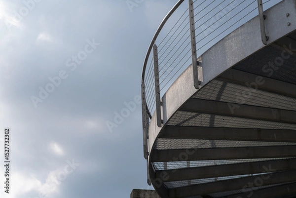 Fototapeta helical pedestrian ramp project in external steel, modern and innovative design staircase, for contemporary architecture. stainless steel design is designed for a pedestrian overpass in a public area.