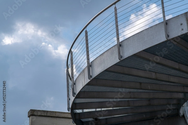 Fototapeta helical pedestrian ramp project in external steel, modern and innovative design staircase, for contemporary architecture. stainless steel design is designed for a pedestrian overpass in a public area.