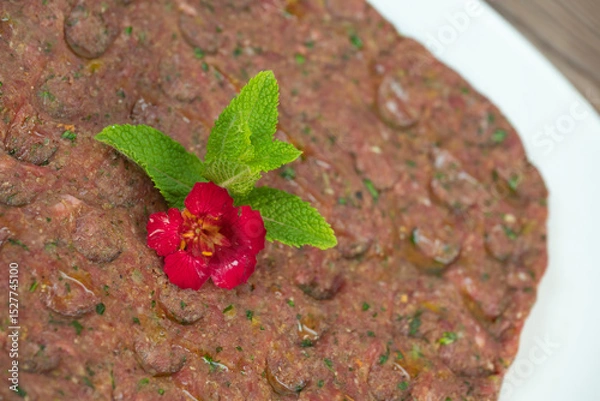 Obraz Kebbe naye is showcased on a white plate, featuring finely chopped raw meat mixed with bulgur, onions, mint, and spices, designed for a rich culinary experience.