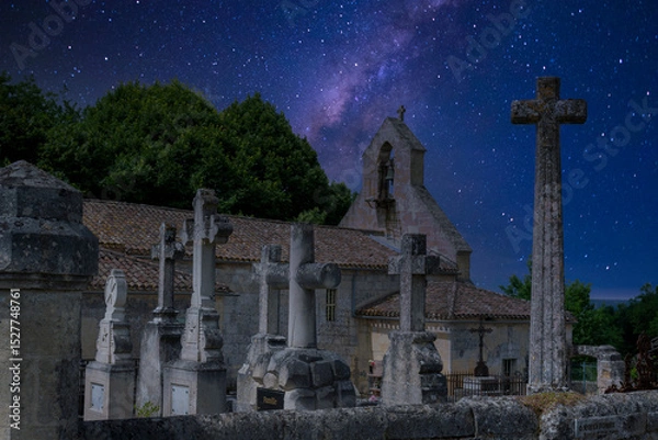 Obraz In Saint-Laurent-des-Combes, stone crosses stand solemnly in a quiet cemetery, framed by a stunning night sky filled with stars. The church adds to the serene atmosphere.