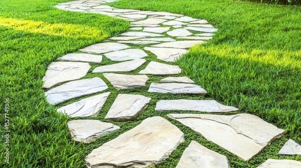 Fototapeta Curved hardscaping stone pathway with irregular flagstones set in vibrant green grass under natural daylight