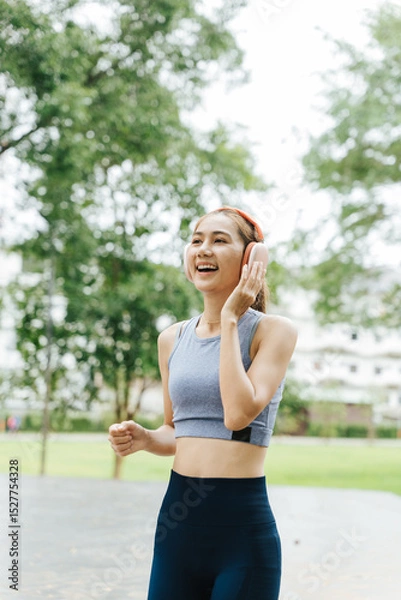 Fototapeta Jogging woman in athletic wear urban park fitness activity green environment dynamic viewpoint healthy lifestyle