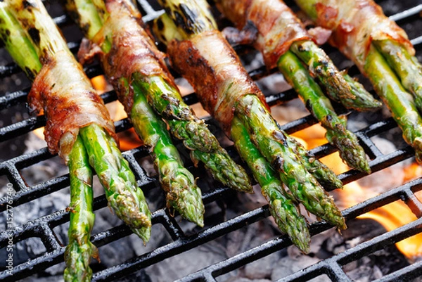 Obraz Grilled green asparagus wrapped in bacon on a cast iron grill, close-up view