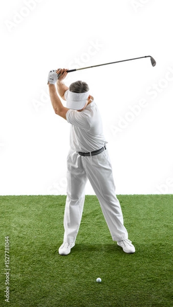 Fototapeta Golfer lifting club high for a strong swing while standing on green grass, dressed in classic attire and focused on ball against white backdrop. Concept of luxury sport, tournament, leisure