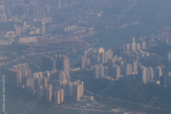 Fototapeta Aerial view from a Cathay Pacific plane over the various Islands of Hong Kong and the financial district with many high-rise skyscrapers creating a dense country