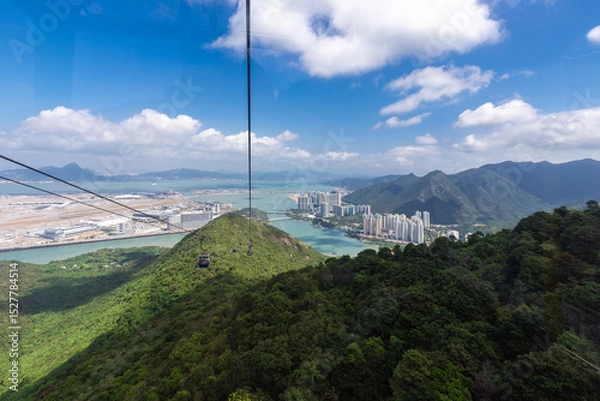 Fototapeta Lantau Island, Hong Kong, 10-20-2024 Views over Lantau Island seen from the cable car which connects downtown Tung Chung and Ngong Ping with the statue of the biggest buddha and the Po Lin Monastery