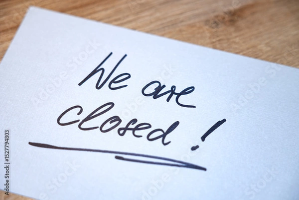 Fototapeta We are closed! White note with handwritten text. Business, retail place, closed, message, information sign.