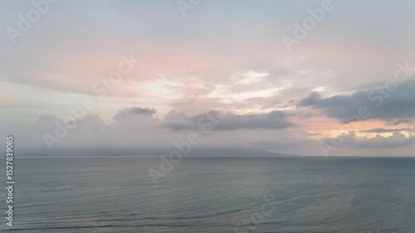 Fototapeta Beautiful cloudy red sunrise over sea with beach, waves and mountains in the background. Impressive structure texture in the sky