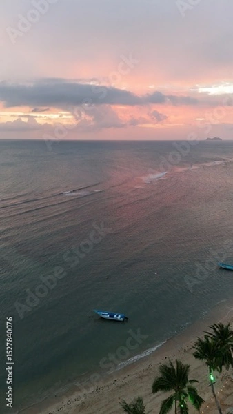 Fototapeta Beautiful cloudy red sunrise over sea with beach, waves and mountains in the background. Impressive structure texture in the sky