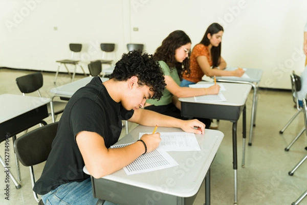 Obraz Concentrated high school students taking exam in classroom