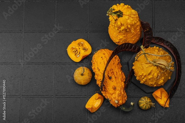 Obraz Organic ornamental pumpkins with textured skin and cut slices on dark background. Natural concept
