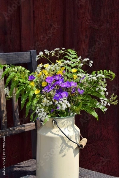 Obraz A bouquet of wild flowers in a milk can for Midsummer at the old red house.