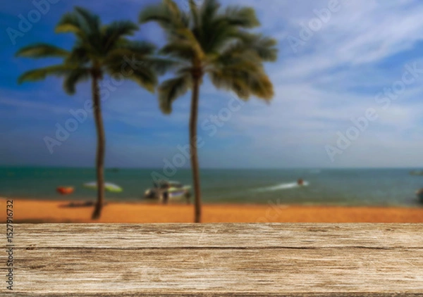 Obraz Wooden table top on the beach or sea and coconuttrees .Party on the beach  daytime concept.For montage product display or design key visual layout.View of copy space.