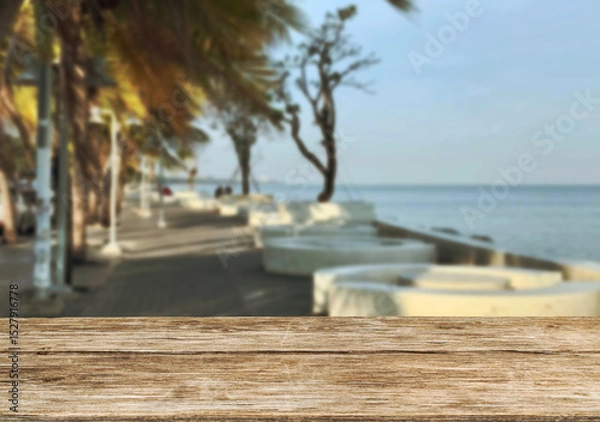 Obraz Wooden table top on the beach or sea and coconuttrees .Party on the beach  daytime concept.For montage product display or design key visual layout.View of copy space.