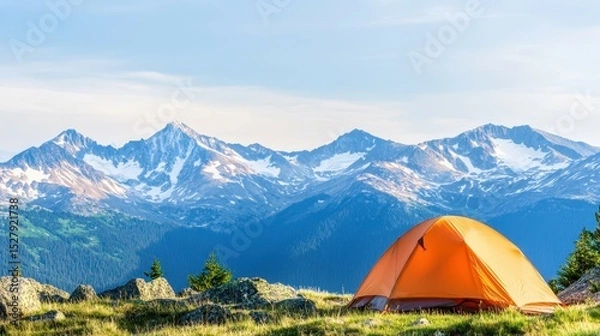 Fototapeta Camping Adventure: A vibrant orange tent sits amidst a breathtaking panorama of rugged mountains under a bright sky, inviting adventure and exploration.