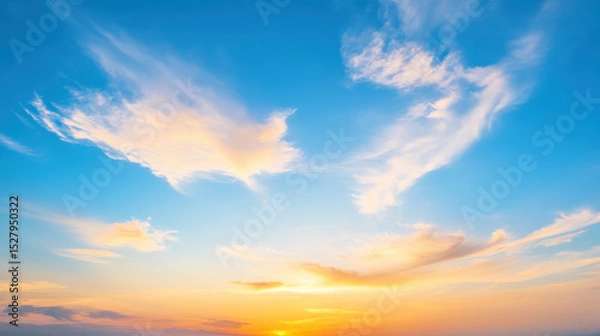 Obraz beautiful celestial sky with wispy clouds illuminated by golden hues.