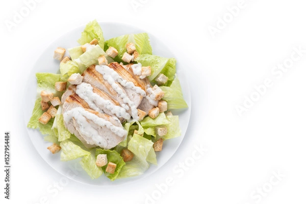 Fototapeta Crunchy Caesar salad with chicken isolated on white background. Top view. Copy space