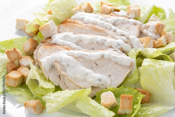 Fototapeta Crunchy Caesar salad with chicken isolated on white background