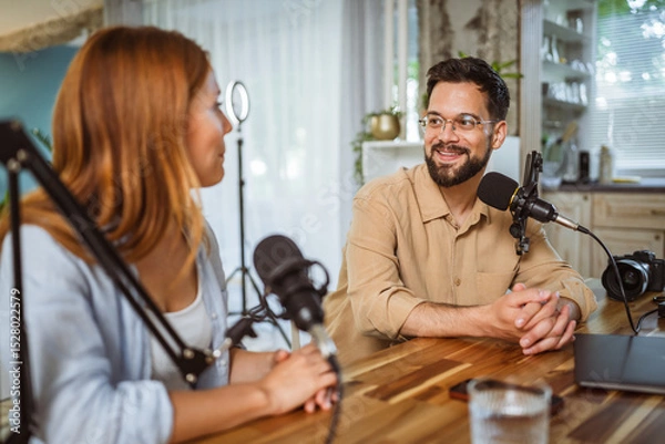 Obraz man and woman host and guest in podcast at home studio
