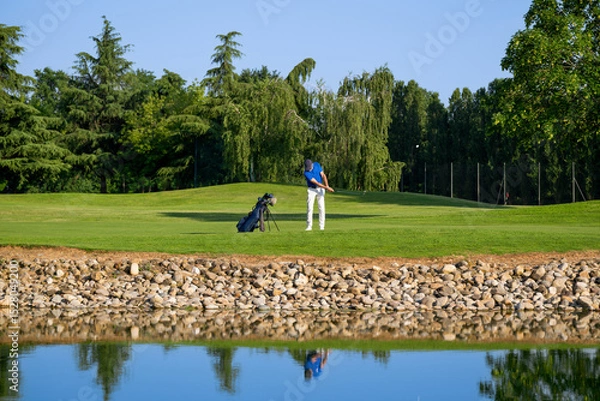 Fototapeta Golfer swinging his club on a sunny day at the golf course