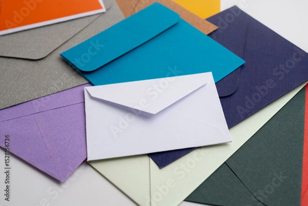 Fototapeta Paper envelopes on a light background. New mail, write a message. Send and receive mail. Postal delivery service. Empty envelope, empty space. Communication with people, paperwork. Envelope close-up
