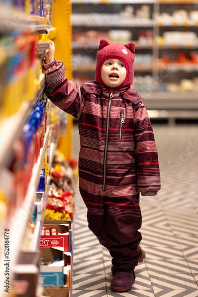 Fototapeta The child looks with a request to buy