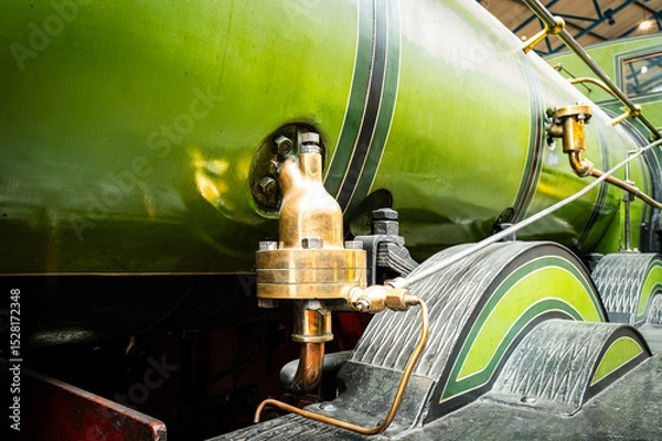 Fototapeta Shallow focus of a brass, steam valve fitting on a green painted, old steam powered locomotive within a, North Yorkshire railway museum. The high pressure brass relief valve can be seen.