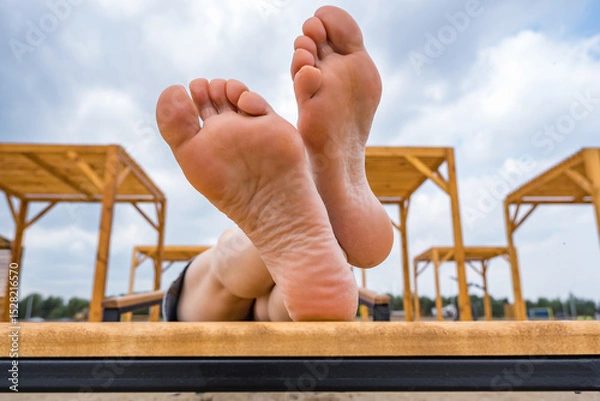 Fototapeta female feet and heels close-up, concept of laziness, idleness and relaxation on the beach in summer