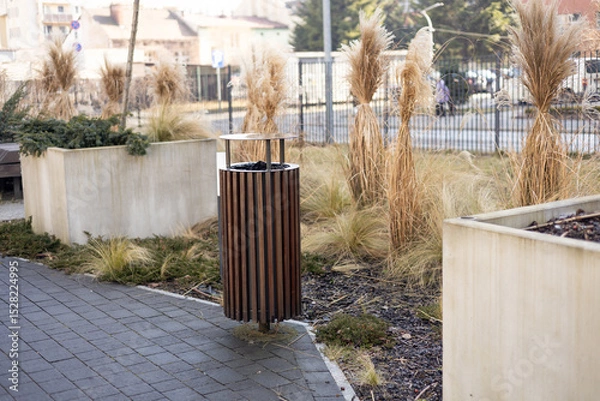 Obraz Wooden Public trash can on a city street filled with garbage. Garbage bin in park with blurred background