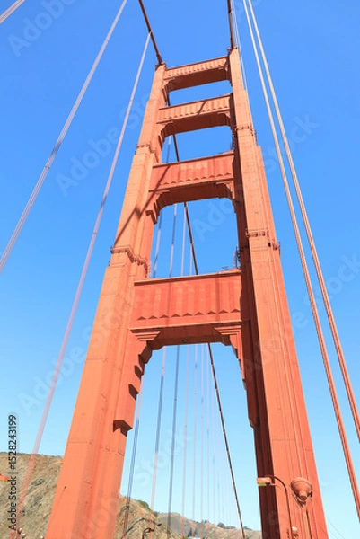 Fototapeta Close up of single tower of Golden Gate Bridge in white clouds San Francisco, USA, bottom view
