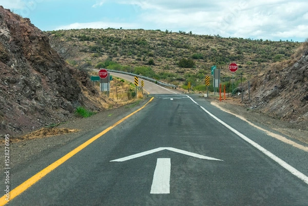 Fototapeta Arrow on the road in the countryside indicating the right path.