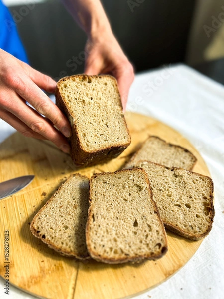 Fototapeta Artisanal gluten free bread held with care. Perfect for small bakery branding, social media, and rustic cooking scenes.