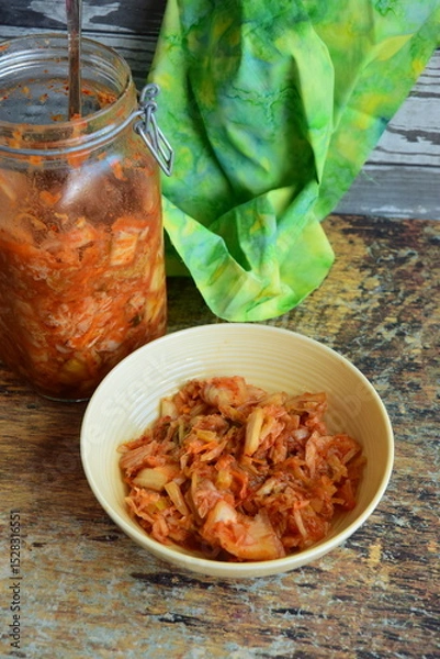 Obraz Napa cabbage kimchi in a bowl and jar, Korean fermented side dish food.
