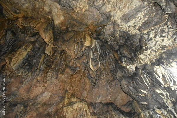 Fototapeta Intricate cave formations with varying textures and colors, illuminated by light.