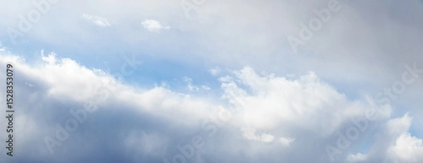 Obraz A low-angle view of a cloudy sky with sunlight breaking through the upper clouds