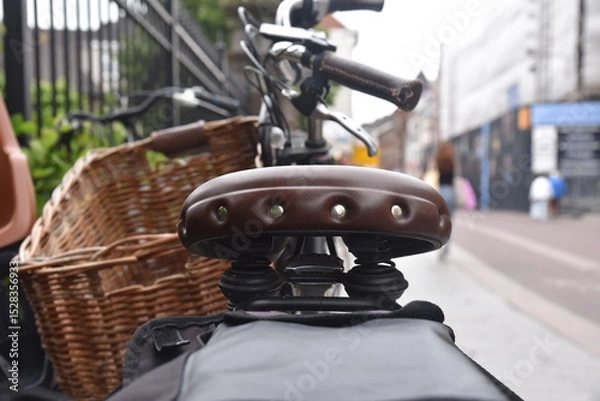 Obraz A closeup shot with shallow focus of a leather bicycle saddle on a busy shopping streed with blurred background. Concept of cycling as transport. 