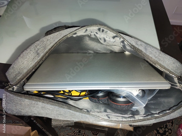 Fototapeta A silver laptop with the brand name HP on it is sitting in a bag