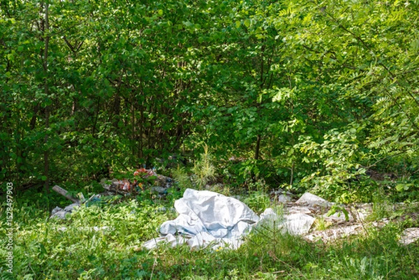 Fototapeta Plastic and polyethylene trash thrown into the thicket of trees