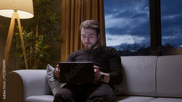 Obraz Man using tablet at night on sofa