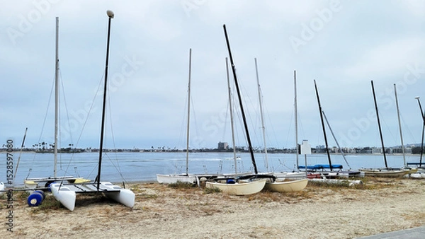 Fototapeta Collection of small catamarans and boats lined up on a sandy beach of Sail Bay, north of San Diego, California