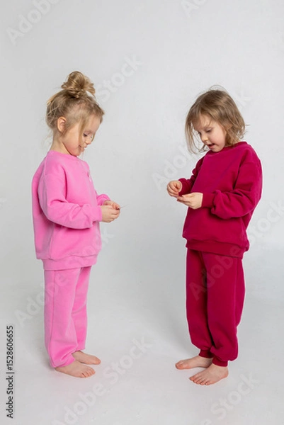 Obraz Two funny cute girls playing and having fun. Children with smiles and funny emotions on a light background. Vertical photo. High quality photo