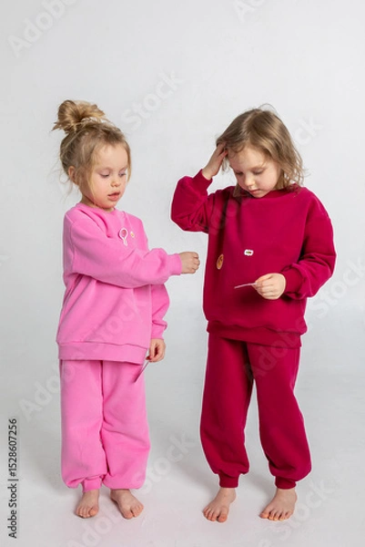 Obraz Two funny cute girls playing and having fun. Children with smiles and funny emotions on a light background. Vertical photo. High quality photo