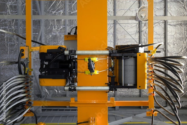 Fototapeta Overhead crane in factory or warehouse. Industrial machine or lifting equipment with hoist, hook and wire rope on beam girder structure for manufacturing production and freight shipping transport.