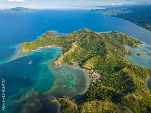 Fototapeta Tropical island surrounded azure water atoll and coral reefs. Sleeping Dinosaur Island. Mati, Davao Oriental. Philippines.