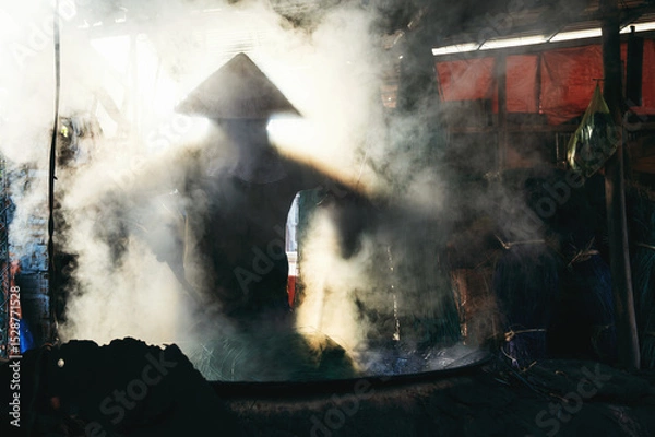 Fototapeta Vietnamese woman worker works in reed dyeing workshop at wicker mat factory in village in Vietnam
